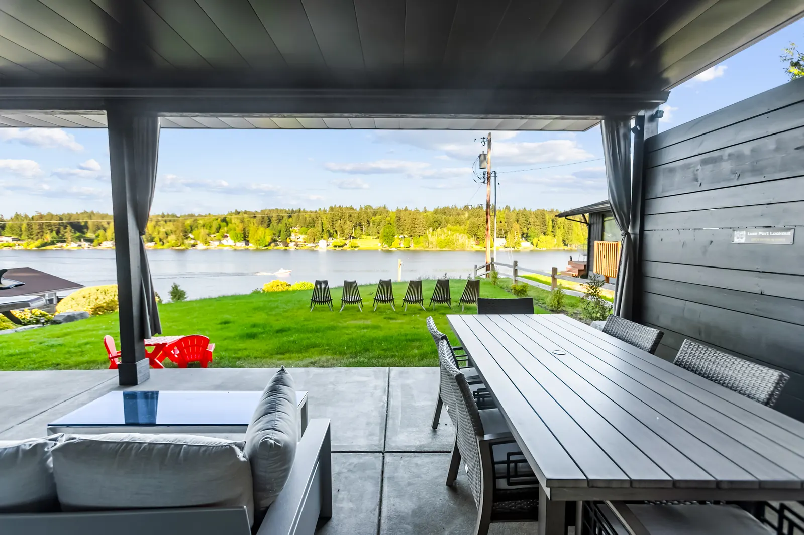 Covered lower deck with dining table and lake view