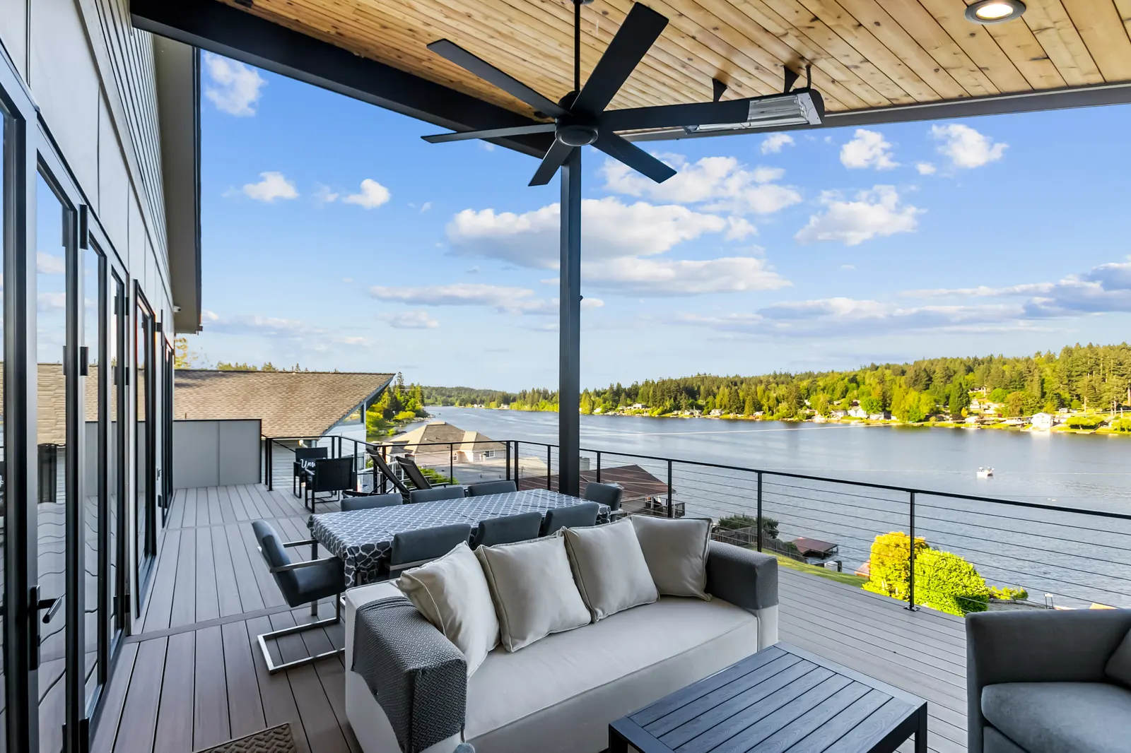 Massive covered upper deck with dining table and lake view at Luxe Port Lookout