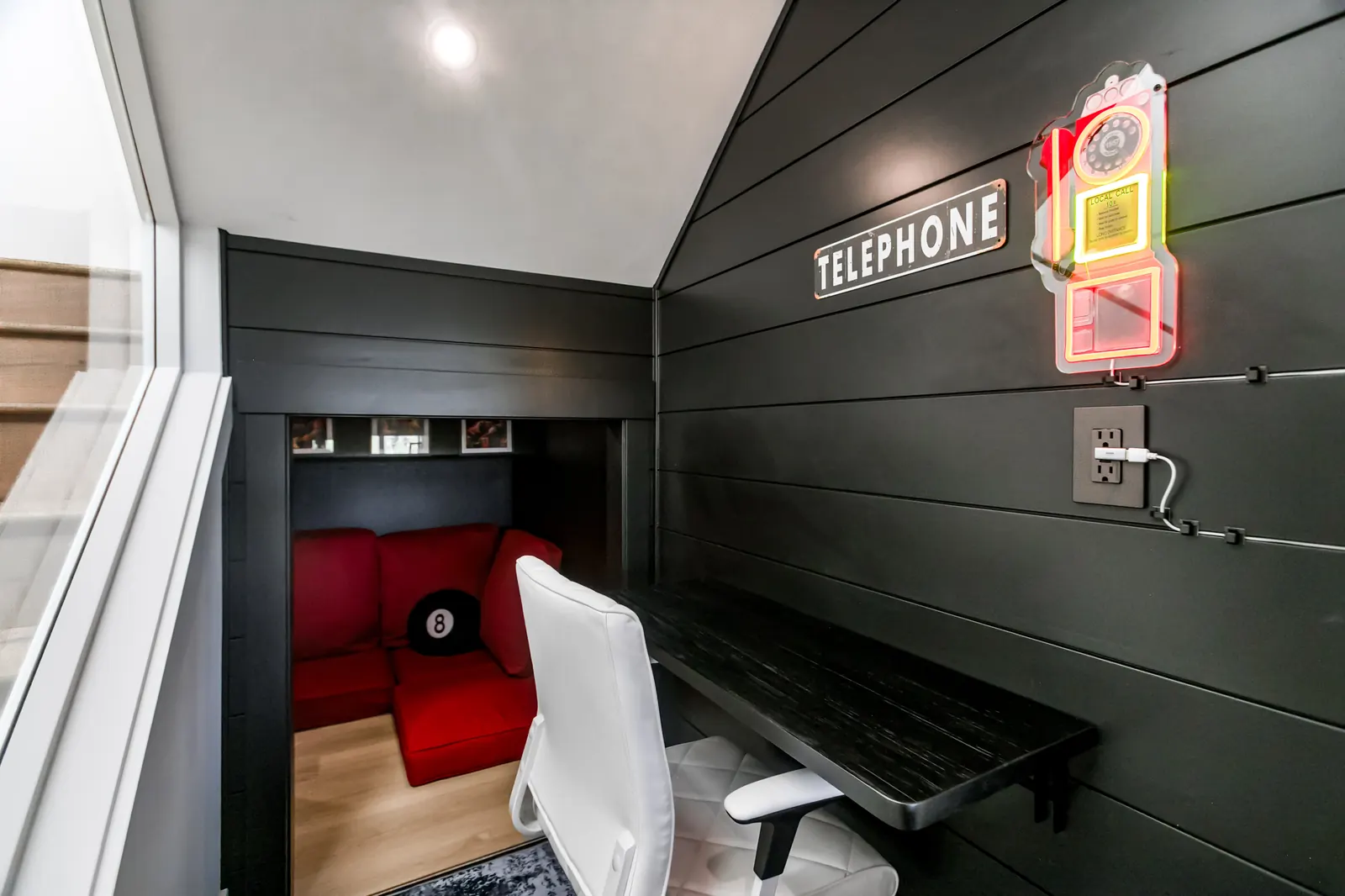 Phone booth nook with pull-down desk opening into a kids' play space